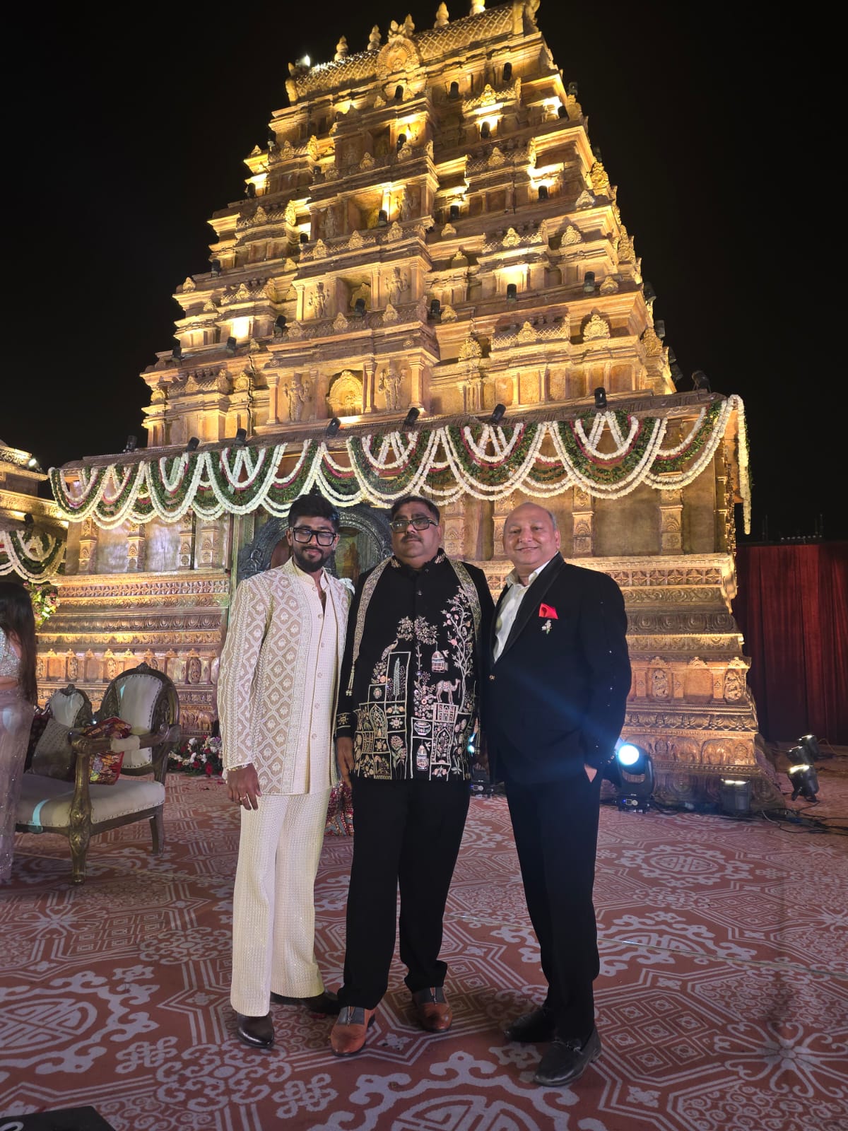 Mr. Manoj Garg with the groom and a guest at a temple-themed reception
